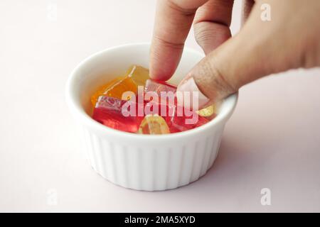 Wählen Sie von Hand farbenfrohe Süßigkeiten aus Stockfoto