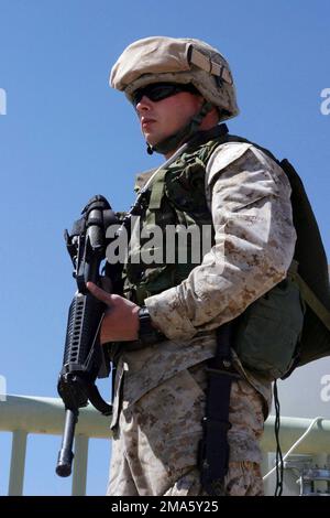 US Marine Corps (USMC) Lance Corporal (LCPL) William E. Bogielski, ein NUKLEAR-, Biologie-, Chemie- (NBC) SPEZIALIST der Marine Wing Headquarters Squadron Two (MWHS-2), steht während der Stationen des Cross Service, der im Fußballstadion des Luftwaffenstützpunkts Al Asad gehalten wird, mit einem 5,56mm-M16A2-Gewehr bewaffnet. Befindet sich während der Operation „IRAQI FREEDOM“ in der Provinz Al Anbar im Irak. Operation/Serie: IRAKISCHE FREIHEITSBASIS: Al Asad Staat: Al Anbar Land: Irak (IRQ) Stockfoto