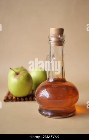 apfelessig in Glasflasche mit frischem grünen Apfel auf Tabelle Stockfoto