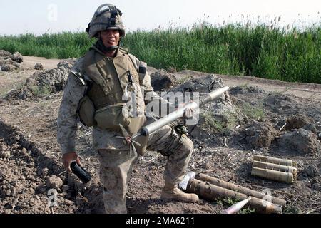 Sergeant (SGT) McCombs, 3. Bataillon, 8. Marines (3/8), Lima Company, zweiter Zug, Zeigt eine 120mm Rakete, die im Dreck vergraben gefunden wurde, mit einem Waffenlager in der Nähe von Karmah, Irak. Die Marines mit 3/8 führen in der irakischen Provinz Al Anbar eine Sicherheits- und Stabilisierungsoperation (SASO) zur Unterstützung der IRAKISCHEN FREIHEIT durch. Operation/Serie: IRAKISCHE FREIHEITSBASIS: Fallujah Staat: Al Anbar Land: Irak (IRQ) Stockfoto