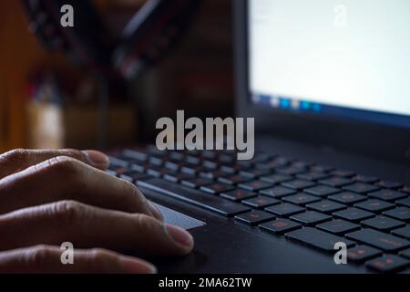 Die Hände tippen auf der Tastatur, arbeiten zu Hause mit einem Laptop Stockfoto