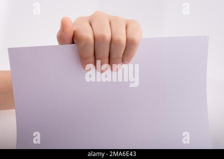Hand hält ein weißes Blatt Papier auf weißem Hintergrund Stockfoto