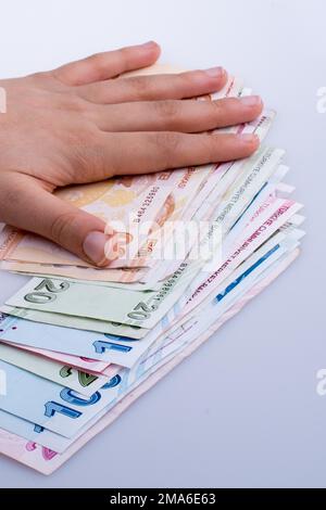 Hand hält die Turksh Lira Banknoten auf weißem Hintergrund Stockfoto