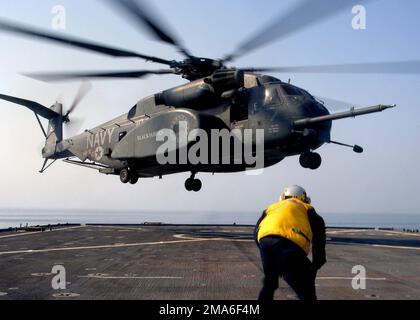 US Navy (USN) SEEMANN (SN) Devon Jamison wartet im Vordergrund, als ein MH-53E Sea Dragon Helicopter, der den „Blackhawks“ des Helicopter Mine Countermeasure Squadron One Five (HM-15) zugewiesen wurde, landet auf dem Flugdeck der USN Whidbey Island Klasse: Amphibiendock Landing Ship USS GUNSTON HALL (LSD 44), während der Übung NAUTICAL UNION. DIE US-Streitkräfte und die Koalitionsstreitkräfte nehmen an der Übung Teil, die darauf abzielt, die Ausbildung im Bereich der maritimen Sicherheitseinsätze (MSO), die Luftverteidigung, die Unterwasserkampfführung, die oberirdische Kriegsführung, die Minenabwehr, Elektronische Kriegsführung, Wiederauffüllung auf See (RAS) und Kommando und Stockfoto