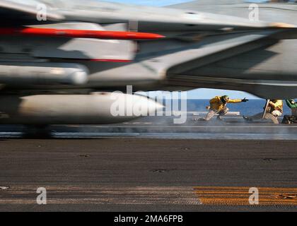 Ein US Navy (USN) Yellow Shirt Katapult Officer, hält seine Position, während er eines der letzten F-14B Tomcats-Flugzeuge startete, das den „Schwertmännern“ von FIGHTER Squadron Three Two (VF-32) vom Flugdeck der Nimitz-Klasse: Aircraft Carrier, USS HARRY S. TRUMAN (CVN-75) zugeteilt wurde. In der aktuellen Phase nimmt die F-14 Tomcat zum letzten Mal an Bord der Truman Teil. VF-32 wird in Kürze mit dem Übergang zum neuen F/A-18F Super Hornet-Flugzeug beginnen. Basis: USS Harry S. Truman (CVN 75) Land: Atlantik (AOC) Stockfoto