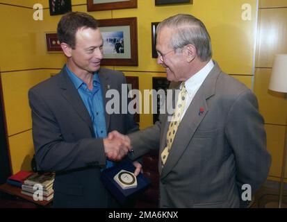 050804-F-6911G-001. [Complete] Szene Caption: Der ehrenwerte Verteidigungsminister Donald H. Rumsfeld (rechts) überreicht dem Schauspieler Gary Sinese bei einem Besuch der CBS-Studios in Los Angeles, Kalifornien, am 4. August 2005 ein eingeprägtes Kalkstein-Pentagon. Minister Rumsfeld besuchte die CSI, um sich persönlich bei Sinise für seine Unterstützung des 'America Supports You' Programms durch seine 'Operation Iraqi Children' zu bedanken. Sinise ist Mitbegründer der Operation Iraqi Children mit der Seabiscuit-Autorin Laura Hillenbrand. Die Organisation sammelt und verschifft Schulbedarf und -Spielzeug nach Irak, um sie von der US-Polizei zu vertreiben Stockfoto