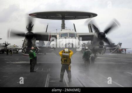 US Navy (USN)-Matrosen, die an Bord des Flugzeugs Carrier, USS KITTY HAWK (CV 63), der Besatzung des Flugdecks zugeteilt sind, bereiten sich während der dritten jährlichen gemeinsamen Luft- und Seetraining (JASEX) auf den Start einer USN E-2C Hawkeye vor, die der Fluggesellschaft Airborne Early Warning Squadron One Five (VAW-115) zugeteilt wurde. Während des Einsatzes im westlichen Pazifik vor der Küste von Yokosuka, Japan. Betreff Betrieb/Serie: JASEX-Basis: USS Kitty Hawk (CV 63) Land: Japan (JPN) Stockfoto