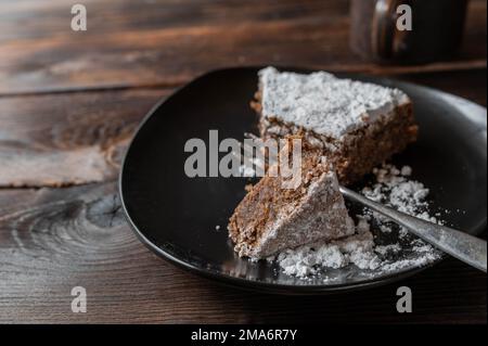 Ein Stück Schokoladenkuchen auf einem braunen Teller. Traditionelle italienische Torta Caprese Stockfoto