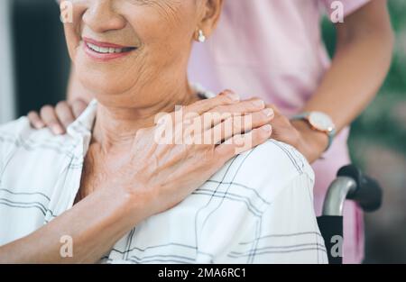 Halt durch, für all den Sonnenschein unserer Vergangenheit. Eine Krankenschwester, die sich um eine ältere Frau im Rollstuhl kümmert. Stockfoto