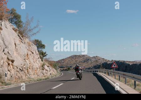 Motorradfahrer, die mitten auf der Insel unterwegs sind, mit einer atemberaubenden Aussicht Stockfoto