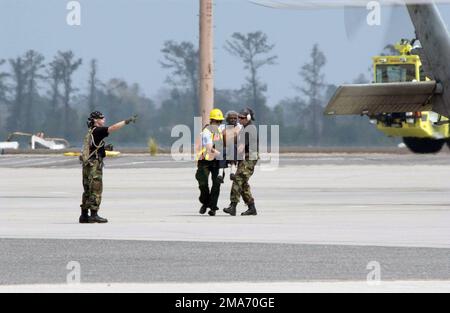 Ein Evakuierter wird von einem Militärpersonal aus einem Hubschrauber am Louis Armstrong International Airport (MSY) in New Orleans, Louisiana (LA), zur Unterstützung der Hilfsmaßnahmen des Hurricane Katrina transportiert. Basis: New Orleans Bundesstaat: Louisiana (LA) Land: Szene der Vereinigten Staaten von Amerika (USA) Hauptkommando gezeigt: JTF-KATRINA Stockfoto