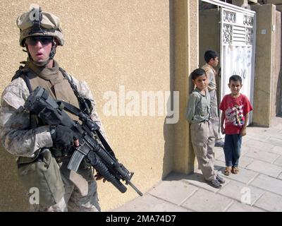 Eine Gruppe irakischer Kinder beobachtet das US Marine Corps (USMC) Lance Corporal (LCPL) Kenneth R. Fouse von Firma C, 1. Bataillon, 6. Marines Regiment, als er Sicherheitskräfte bereitstellt, bewaffnet mit einem 5,56mm M16A2-Gewehr, ausgestattet mit einem M203 40mm-Granatwerfer. Während einer Such- und Löschaktion innerhalb der Innenstadt von Fallujah, Irak. Die der 2. Marine-Division zugewiesenen Marines des USMC führen mit den irakischen Sicherheitskräften (ISF) Aufstandsbekämpfungsoperationen durch, um die antiirakischen Kräfte zu isolieren und zu neutralisieren, um die Freiheit der Operation IRAQI zu unterstützen. Operation/Serie: IRAKISCHE FREIHEITSBASIS: CAM Stockfoto