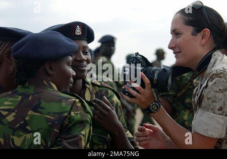 Sergeant (SGT) des US Marine Corps (USMC) Leah Cobble, Public Affairs, zeigt weiblichen Soldaten der kenianischen Armee auf der Stony-Athi-Range in Nairobi, Kenia (KEN), ein Bild auf ihrer Digitalkamera. Niederländische, französische und US-amerikanische Mitglieder der kombinierten Joint Task Force - Horn von Afrika (JTF-HOA) nehmen an der Ostafrikanischen Rifle-Meisterschaft der Streitkräfte in Nairobi Teil. Basis: Stony-Athi Range Staat: Nairobi Land: Kenia (KEN) Stockfoto