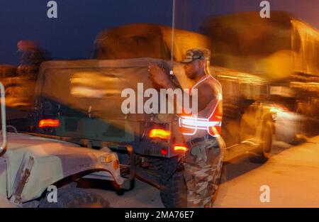 US Army (USA) SPECIALIST (SPC) Joseph Thorne vom 3. Bataillon, 112. Field Artillery, führt Fahrzeuge in Position, wenn sie an der Zwischenstation in der Nähe von Alexandria, Louisiana (LA) ankommen, um den Hurrikan Rita zu unterstützen. (Doppeltes Bild, siehe auch DFSD0608692 oder suchen Sie nach 050925F4970D103) Stockfoto