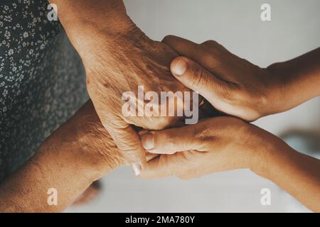 Fürsorgliche ältere Oma Frau hält Hand unterstützt älteren Opa Ehemann geben Mitgefühl Pflege Liebe, alte verheiratete Großeltern Paar zwei Mann und Stockfoto
