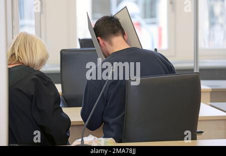 Rostock, Deutschland. 19. Januar 2023. Beate Falkenberg (l-r), Anwalt, und der Angeklagte im Triple-Mordprozess warten im Gerichtssaal auf die Fortsetzung des Prozesses. Der 27-jährige Mann soll im Februar letzten Jahres in Rövershagen seine Eltern und seine Schwester getötet haben. Kredit: Bernd Wüstneck/dpa/Alamy Live News Stockfoto