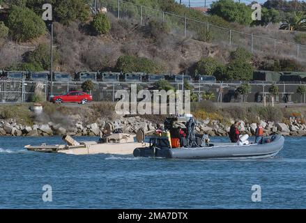 051205-N-9866B-227. [Complete] Scene Caption: Kaum sichtbar hinter dem RHIB (Rigid-Hull Inflatable Boat) bewegt sich das neue EFV (Expeditionary Fighting Vehicle) des US Marine Corps (USMC) während eines Tests im Landebereich des Del Mar Boat Base, Camp Pendleton, Kalifornien (CA) durch das Wasser. Die AAAV wird 18 Marines und eine dreiköpfige Crew mit einer Geschwindigkeit von 29 km/h über Wasser transportieren können, mit einem Rumpf, der von zwei Wasserstrahlen angetrieben wird. An Land erreicht die AAAV Geschwindigkeiten von 45 km/h. Neben der hohen Geschwindigkeit auf dem Land hat das AAAV auch noch genug Stockfoto