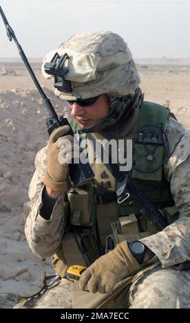 Sergeant Brandon Shofne, 2. Combat Engineers Battalion (CEB) des US Marine Corps (USMC), nutzt ein MBITR AN/PRC-148, um das Hauptquartier mit Beschreibungen der Kampfmittel zu erreichen, die während der Operation IRAQI FREEDOM in Kharma (Irak) gefunden wurden. Basis: Al Kharma Staat: Al Anbar Land: Irak (IRQ) Stockfoto