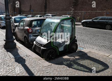 Ein kompakter Kleinstadtwagen von Biro, der auf extrem beengten Parkplätzen in einem ungewöhnlichen Winkel auf den Straßen Roms in Italien geparkt ist. Stockfoto