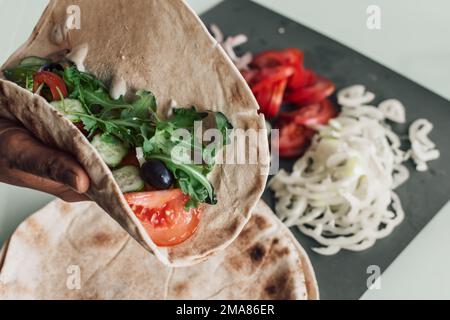 Mediterrane Pitta mit scharfem Huhn, Gurke, Tomaten, Salat und Mayo-Sauce Stockfoto