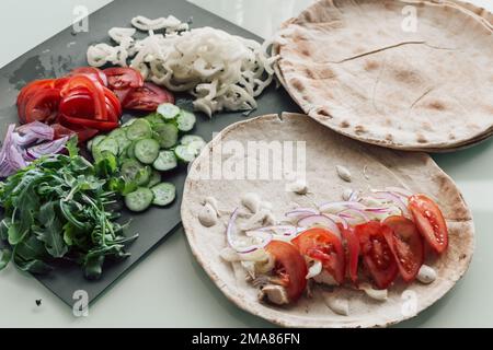 Mediterrane Pitta zubereitet mit scharfem Huhn, Gurke, Tomaten, Salat und Mayo-Sauce, Stockfoto