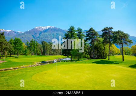 Golfplatz mit schneebedeckten Bergen in Ascona, Tessin, Schweiz Stockfoto