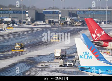 Schneepflüge, die am Flughafen Manchester Schnee pflügen. Die Menschen in vielen Teilen des Landes bereiten sich für ein paar Tage der Reiseunterbrechung vor, da Schnee, Eis und bitterkalte Temperaturen die Nation beherrschen. Foto: Donnerstag, 19. Januar 2023. Stockfoto