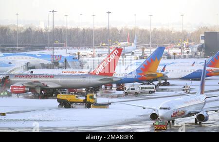 Schneepflüge, die am Flughafen Manchester Schnee pflügen. Die Menschen in vielen Teilen des Landes bereiten sich für ein paar Tage der Reiseunterbrechung vor, da Schnee, Eis und bitterkalte Temperaturen die Nation beherrschen. Foto: Donnerstag, 19. Januar 2023. Stockfoto