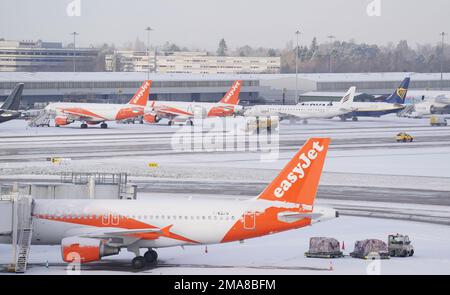 Schneepflüge, die am Flughafen Manchester Schnee pflügen. Die Menschen in vielen Teilen des Landes bereiten sich für ein paar Tage der Reiseunterbrechung vor, da Schnee, Eis und bitterkalte Temperaturen die Nation beherrschen. Foto: Donnerstag, 19. Januar 2023. Stockfoto