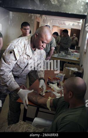 060408-M-8205V-012. [Complete] Szene Caption: US Navy (USN) Hospital Corpsman First Class (HM1) Samuel Cox, der Präventivmedizintechniker, der der Station für Bataillonshilfe, dem Hauptquartier und der Dienstfirma zugewiesen ist, 1. Bataillon, 1. Marine Regiment, Regimental Combat Team Five (RCT-5), Entnimmt Blut von einem US Marine Corps (USMC) Marine an der Forward Operating Base (FOB) Abu Ghurayb (Abu Ghraib). RCT-5 wird mit der ersten Marine Expeditionary Force (I MEF), Forward Dispatch (FWD), zur Unterstützung der Freiheit der Operation IRAQI, in der Provinz Al Anbar im Irak, Multinationale Streitkräfte West (MNF-W), eingesetzt Stockfoto