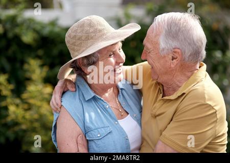 Du bist meine schöne Show. Ein älteres Paar umarmt sich im Garten. Stockfoto