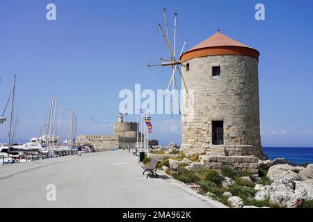 RHODOS, GRIECHENLAND - 10. MAI 2022: Mandraki Marina und Hafen mit Rhodos Windmühlen und Fort von St. Nicholas, Griechenland Stockfoto