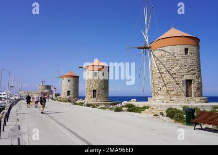 RHODOS, GRIECHENLAND - 10. MAI 2022: Mandraki Marina und Hafen mit Rhodos Windmühlen, Griechenland Stockfoto