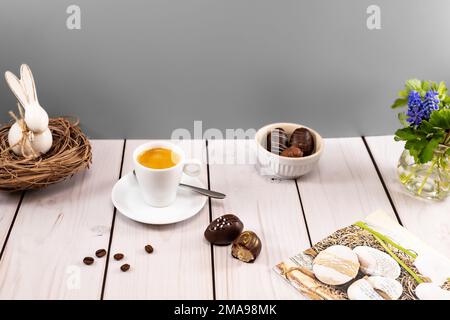 Dekorierte ostereierschokolade mit Espresso am Tischdecken Stockfoto