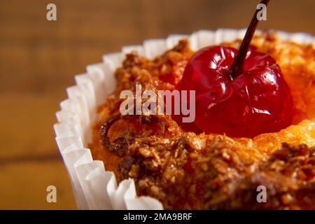 Goiânia, Goias, Brasilien – 18. Januar 2023: Detail eines Bombocados, eines typischen brasilianischen Süßes, gebacken in einer Papierform, mit einer Kirsche oben drauf. Stockfoto