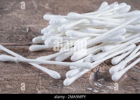 Loser Stapel von Q-Tips Wattestäbchen mit umweltfreundlichen Pappstöcken zum Entfernen von Make-up auf einem unsichtbaren Schreibtisch Stockfoto