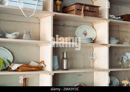 Regal mit altem Geschirr und anderen Gegenständen im Speisesaal. Stockfoto