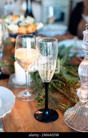 Zwei Gläser mit Alkohol auf dem Silvestertisch. Ein Glas Champagner und ein Cocktail mit Zitrone in einem Glas Stockfoto