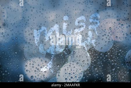 Ich vermisse dich auf nassem Fensterglas. Blauer, verschwommener, körniger Hintergrund mit Stadtlicht und Bokeh. Glas mit Regentropfen und Flecken von Fingerzeichnungen. Abstrakt Stockfoto