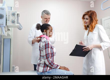Radiologen kommunizieren mit dem Patienten und dokumentieren die Indikationen vor der Röntgenaufnahme der Extremitäten. Stockfoto
