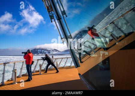 Der Tourist machte Fotos auf dem Hauptdeck des Expeditionsschiffs Greg Mortimer in Svalbard-Archipel, arktisches Norwegen. Stockfoto