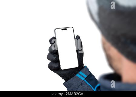 Winterliches Telefonmodell in Männerhand mit Jacke, Handschuhen und Hut. Isoliertes Display und Hintergrund für die App-Präsentation Stockfoto