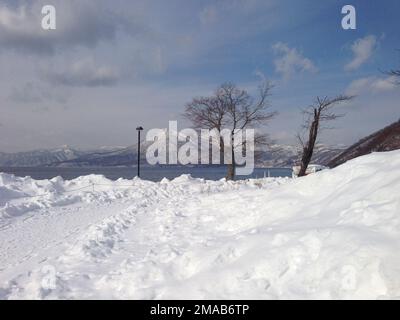 Der Blick auf die Berge am Ufer des Toya-Sees im Winter. Bezirk Abuta, Hokkaido, Japan. Stockfoto