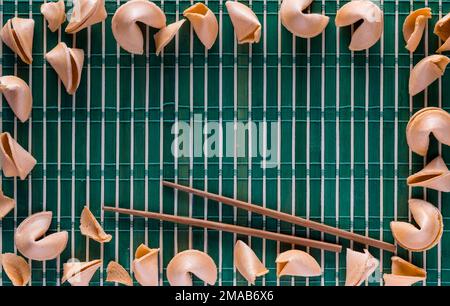 Eine Grenze von Glückskeksen auf einer Bambusmatte mit Stäbchen. Stockfoto