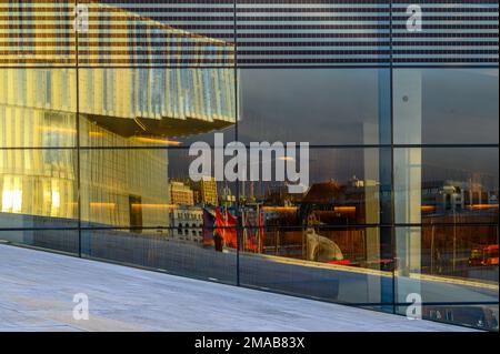 Glasfassade des modernen Osloer Opernhauses mit Reflexion eines Teils der Deichman-Bibliothek in Bjorvika, Oslo, Norwegen. Architekten: Snøhetta. Stockfoto