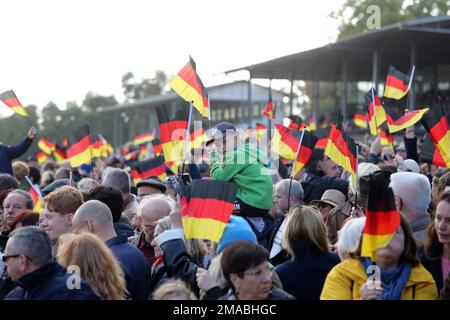 03.10.2022, Deutschland, Brandenburg, Hoppegarten - Menschen, die am Tag der deutschen Einheit die Nationalflaggen schwingen. 00S221003D938CAROEX.JPG [MODELLVERSION: NEIN, M Stockfoto
