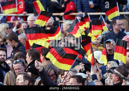 03.10.2022, Deutschland, Brandenburg, Hoppegarten - Menschen, die am Tag der deutschen Einheit die Nationalflaggen schwingen. 00S221003D937CAROEX.JPG [MODELLVERSION: NEIN, MODELLVERSION Stockfoto