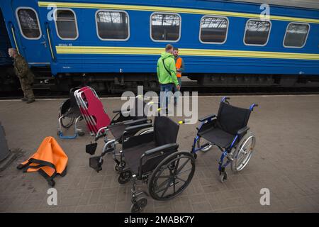 15.04.2022, Ukraine, Oblast, Lemberg - Ukrainische Freiwillige mit Rollstühlen stehen auf dem Bahnsteig neben einem Zug im Hauptbahnhof von Lemberg. Achtung: Nur Stockfoto