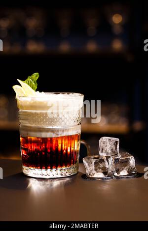 Auf einer Theke und einem dunklen Hintergrund. Alkoholischer Cocktail mit Eis. Stockfoto
