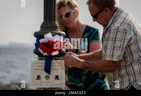 Debra und Gary Holman, überlebende Familie von Tech. Sergeant Steven Holman, bringen Sie ein Gedenkschild für ihren Sohn an einem Leuchtturm auf dem MacDill Luftwaffenstützpunkt, Florida, während der zweiten Gedenkveranstaltung am 25. Mai 2022 an. Freiwillige von MacDill AFB und der umliegenden Gemeinde kamen zusammen, um 75 Schilder um MacDill herum zu Ehren gefallener Soldaten zu platzieren. Stockfoto